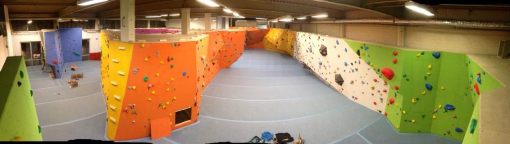 Innenansicht der Boulderhalle von Boulders Habitat Bonn mit bunten Kletterwänden und Mattenfläche