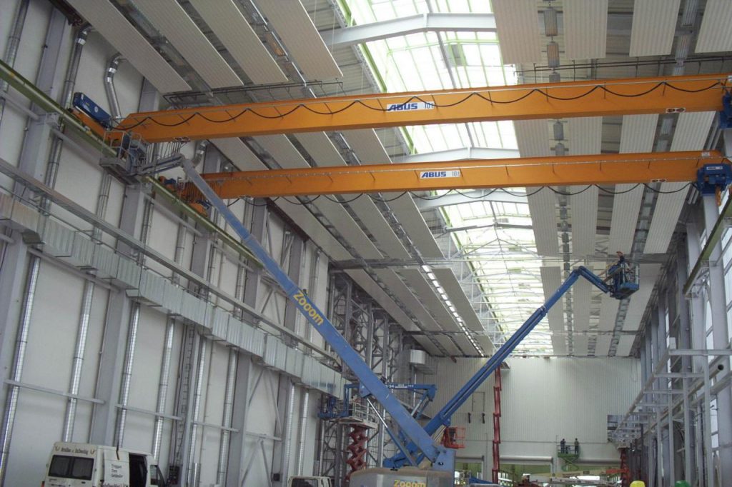 Montagehalle mit Krananlagen und installierten Deckenstrahlplatten unter dem Hallendach mit Lichteinfall